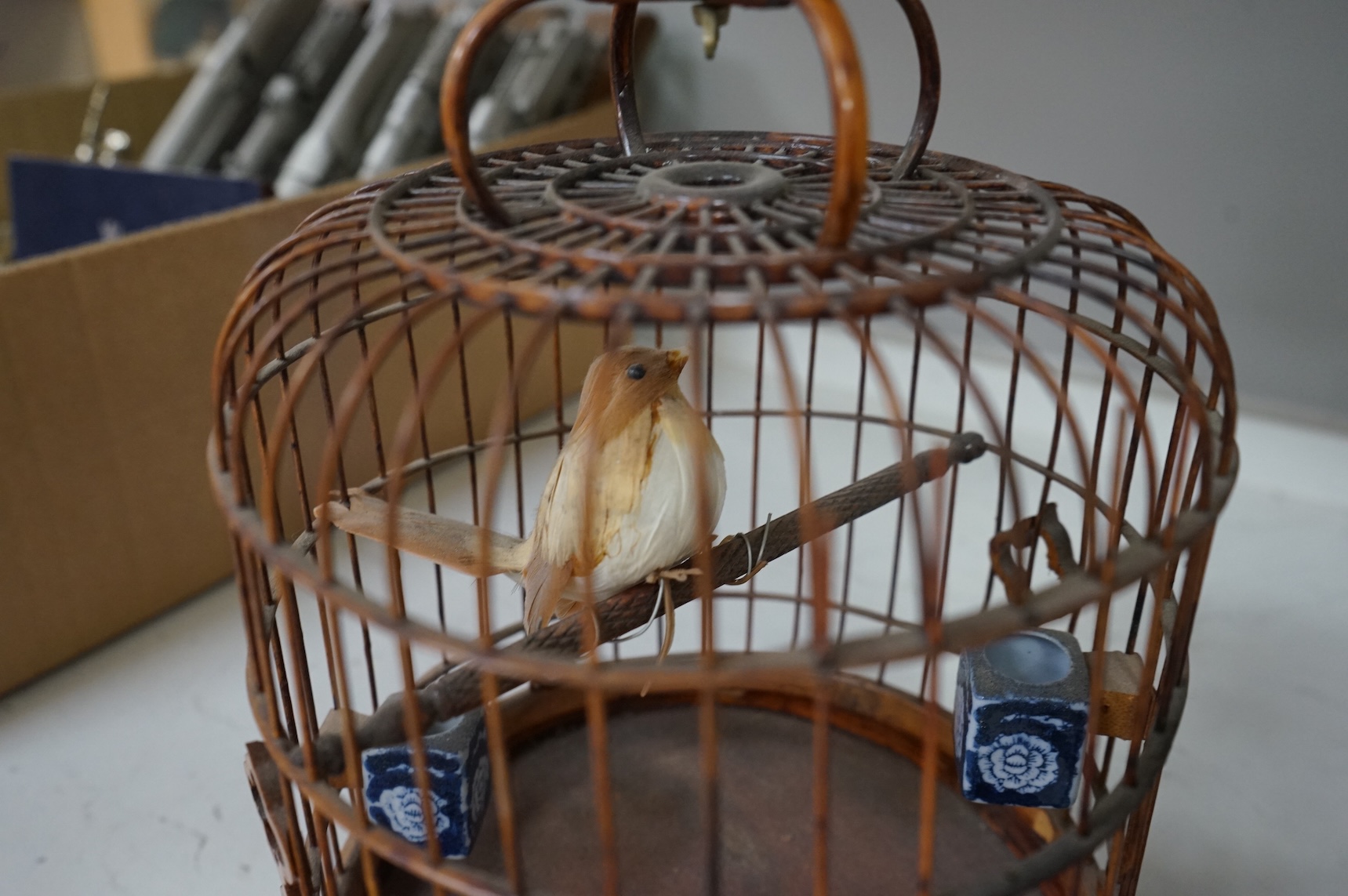 A pair of Chinese bamboo and metal birdcages with blue and white feeders. 34cm high not including hook